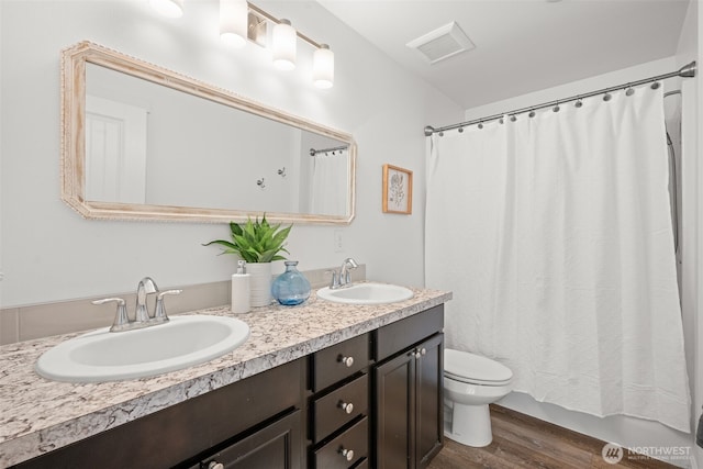 401 E Sunset Ridge Rd, Union, WA 98592 - bathroom with wood finished floors, toilet, double vanity, and shower / bath combo with shower curtain