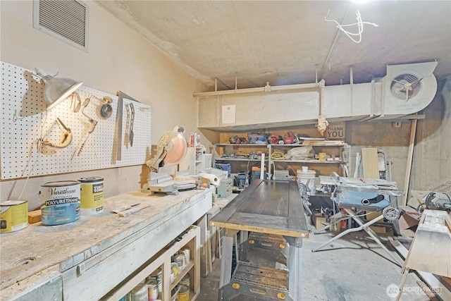 miscellaneous room with a workshop area and concrete flooring