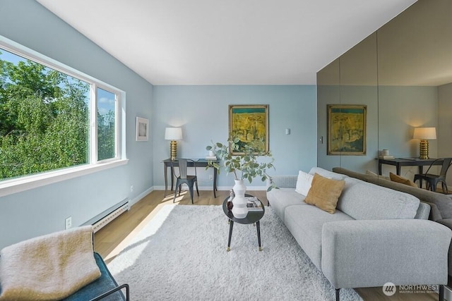 living area with baseboard heating, wood finished floors, and baseboards