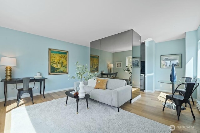 living area with light wood-style floors and baseboards