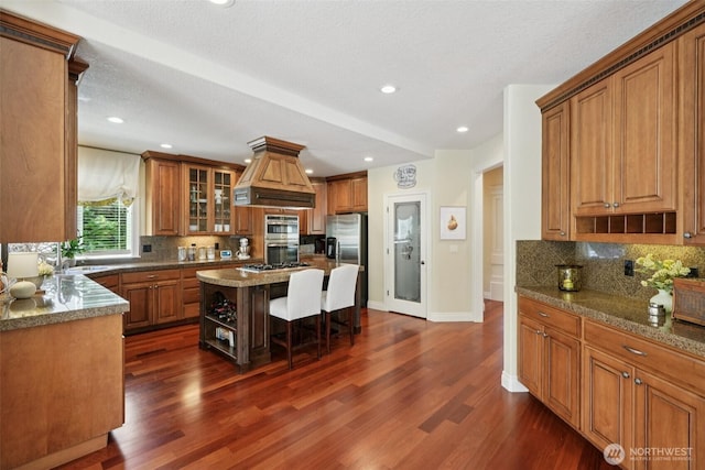 1610 NW 34th Ave, Camas, WA 98607 - kitchen with open shelves, premium range hood, brown cabinets, decorative backsplash, and recessed lighting