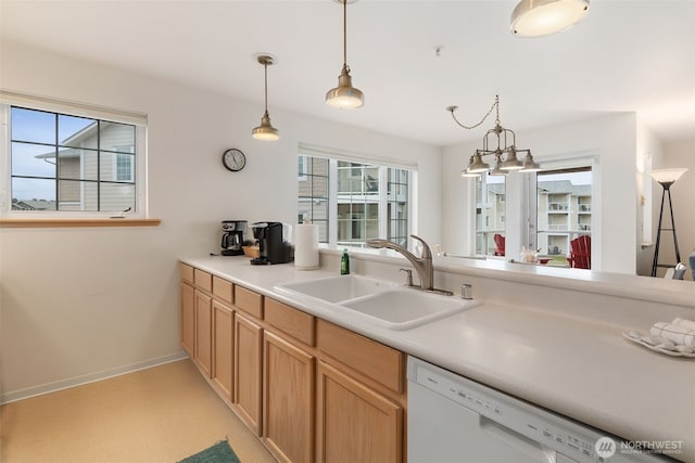 kitchen featuring pendant lighting, a healthy amount of sunlight, a sink, and dishwasher