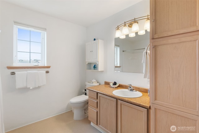 bathroom featuring vanity, walk in shower, and toilet