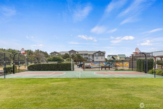 view of basketball court with a lawn, community basketball court, and fence