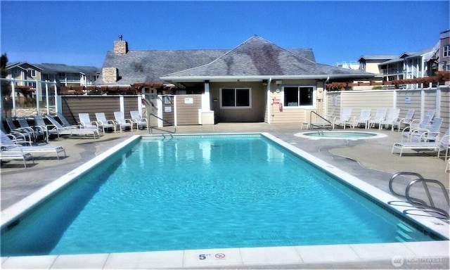 community pool featuring a community hot tub, a patio area, and fence
