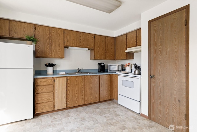 325 NE Kettle St Unit 102, Oak Harbor, WA 98277 - kitchen featuring a sink, white appliances, light countertops, brown cabinetry, and under cabinet range hood