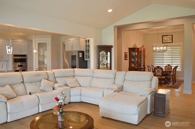 living room with a chandelier, vaulted ceiling, light wood-style floors, recessed lighting, and baseboards