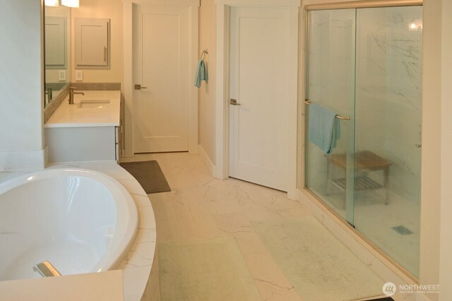 bathroom with a shower stall, a garden tub, marble finish floors, and vanity