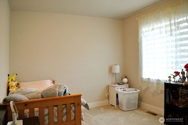 bedroom featuring light carpet and baseboards