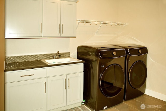 laundry room featuring separate washer and dryer, cabinet space, and tile patterned floors