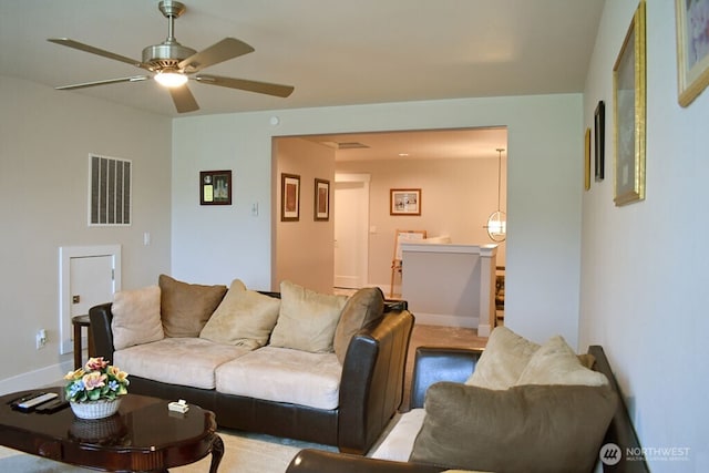 living room with ceiling fan and baseboards