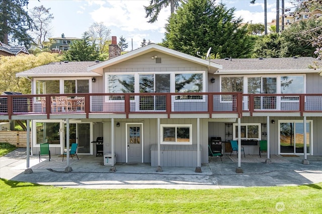 4966 Bradley Ln, Freeland, WA 98249 - rear view of house featuring a shingled roof, a patio, board and batten siding, and a chimney