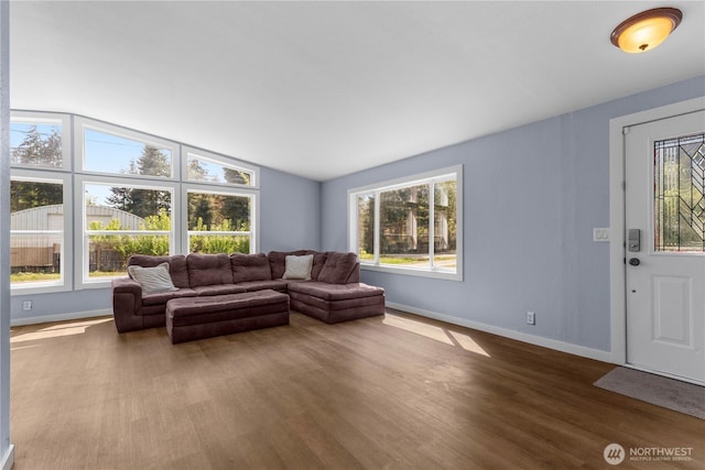 living room with baseboards, dark wood-style floors, and lofted ceiling