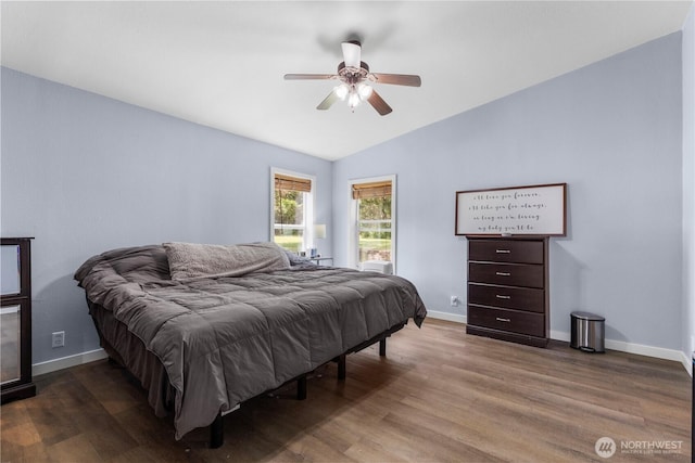 bedroom with vaulted ceiling, wood finished floors, baseboards, and a ceiling fan