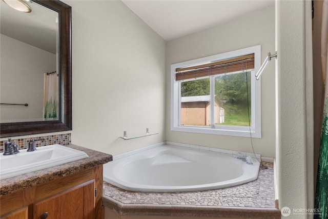 bathroom with vanity, tasteful backsplash, and a garden tub