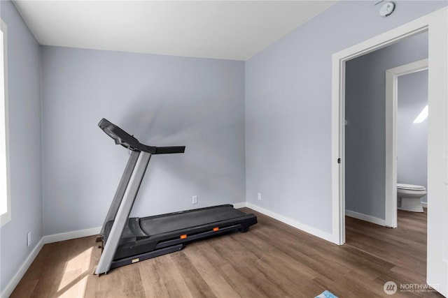 workout area featuring wood finished floors and baseboards