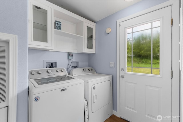 washroom featuring washer and dryer, plenty of natural light, and cabinet space