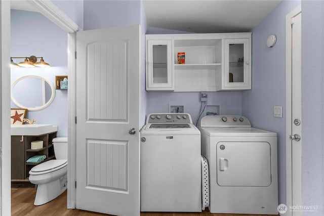 laundry area featuring washer and dryer and wood finished floors