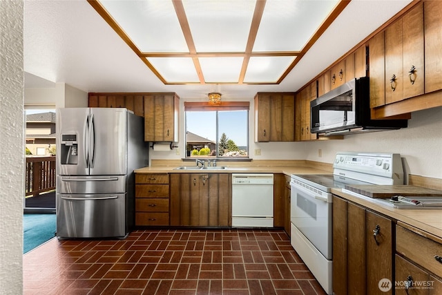 kitchen with a sink, light countertops, stainless steel appliances, and a healthy amount of sunlight