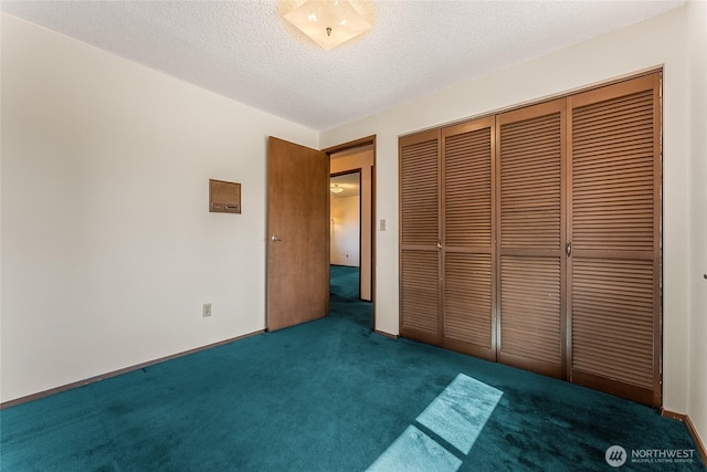 unfurnished bedroom with a closet, a textured ceiling, and carpet
