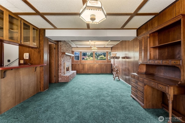 unfurnished room with carpet flooring, wood walls, and a fireplace