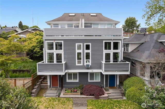 back of property featuring a balcony and fence