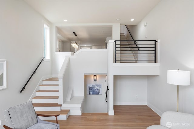 stairway featuring wood finished floors, recessed lighting, and baseboards
