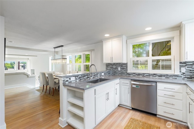 kitchen with dishwasher, a sink, a peninsula, light wood finished floors, and recessed lighting