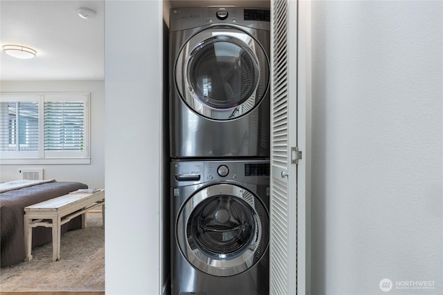 laundry room featuring stacked washer / drying machine