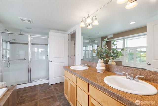 bathroom with a shower stall, double vanity, tile patterned floors, and a chandelier