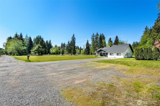 view of green lawn featuring driveway