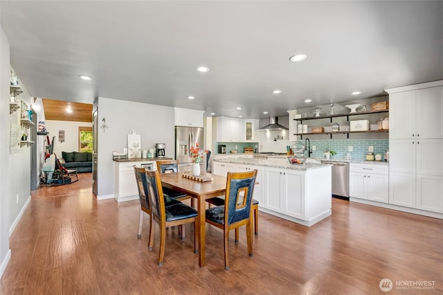 dining space with wood finished floors, recessed lighting, and baseboards