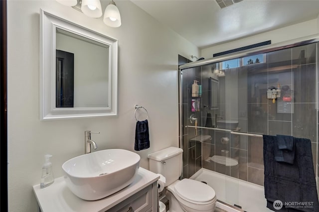 full bath featuring toilet, a shower stall, and vanity