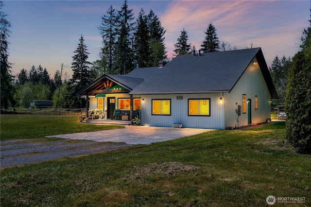 view of front of property with driveway and a lawn