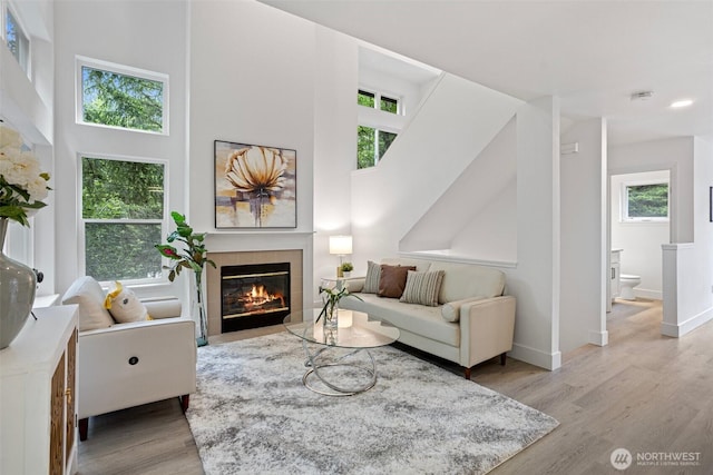3758 257th Ave SE Unit 4-4, Issaquah, WA 98029 - living room with a tiled fireplace, wood finished floors, baseboards, a towering ceiling, and recessed lighting