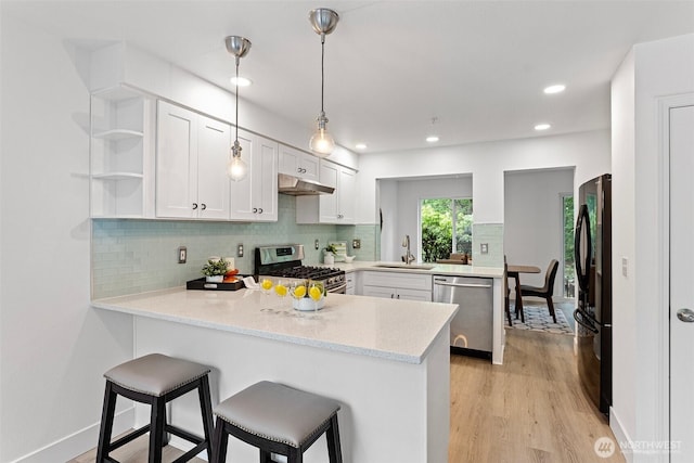 3758 257th Ave SE Unit 4-4, Issaquah, WA 98029 - kitchen featuring appliances with stainless steel finishes, a sink, a peninsula, under cabinet range hood, and open shelves