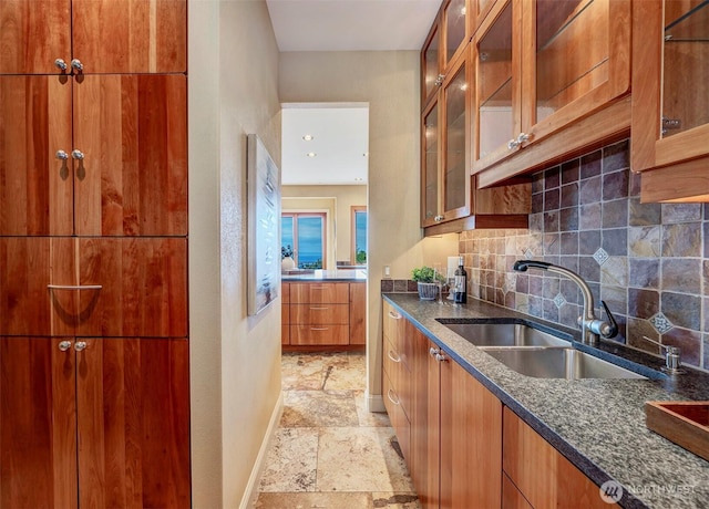 7212 164th St SW, Edmonds, WA 98026 - kitchen featuring stone tile flooring, tasteful backsplash, dark stone counters, brown cabinetry, and glass insert cabinets