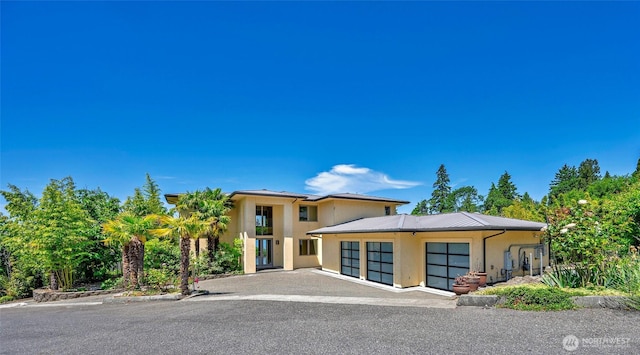 7212 164th St SW, Edmonds, WA 98026 - view of front facade with stucco siding, an attached garage, and a metal roof