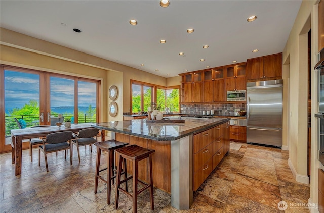 7212 164th St SW, Edmonds, WA 98026 - kitchen with built in appliances, stone tile flooring, a center island, recessed lighting, and brown cabinets