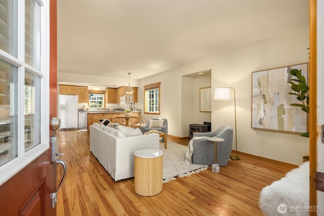 living area with light wood-style flooring and baseboards