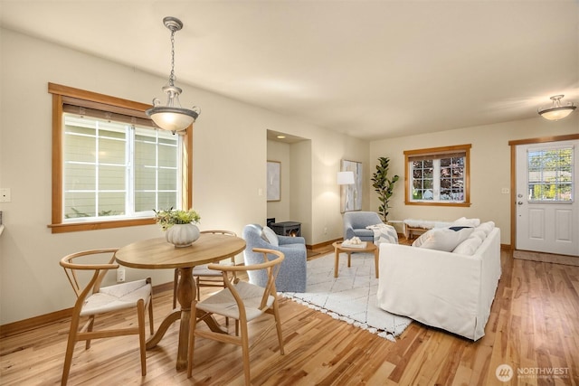 dining area featuring light wood finished floors and baseboards