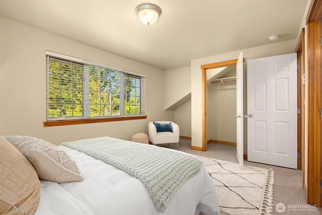bedroom featuring baseboards, a closet, and light colored carpet