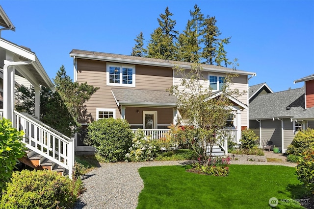 rear view of house with covered porch, stairs, and a lawn