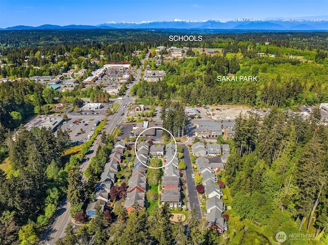 birds eye view of property featuring a forest view, a mountain view, and a residential view