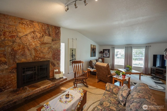 201 S Cherry St, Dayton, WA 99328 - living room featuring a textured ceiling, a stone fireplace, wood finished floors, and lofted ceiling