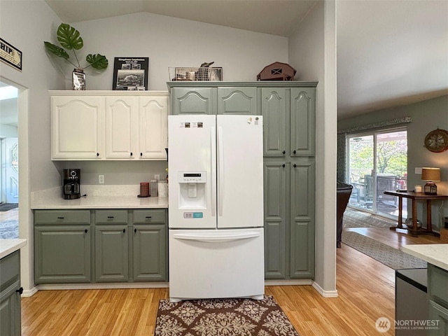 401 Dungeness Mdws, Sequim, WA 98382 - kitchen featuring white fridge with ice dispenser, light wood-type flooring, vaulted ceiling, light countertops, and gray cabinetry