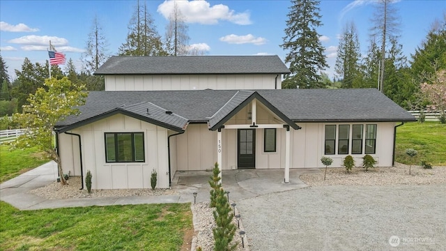 modern farmhouse with a shingled roof and board and batten siding
