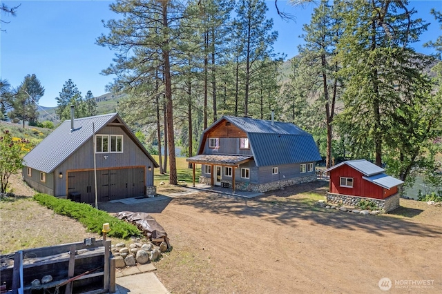 69 Ross Rd, Twisp, WA 98856 - view of front of property featuring a gambrel roof, metal roof, a garage, an outbuilding, and a mountain view