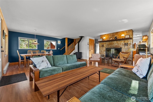 69 Ross Rd, Twisp, WA 98856 - living area featuring stairway, wood finished floors, a stone fireplace, and baseboards