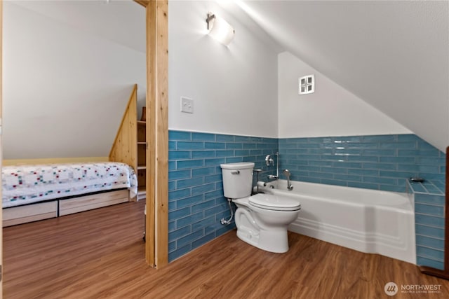 69 Ross Rd, Twisp, WA 98856 - full bathroom featuring tile walls, vaulted ceiling, toilet, a tub, and wood finished floors